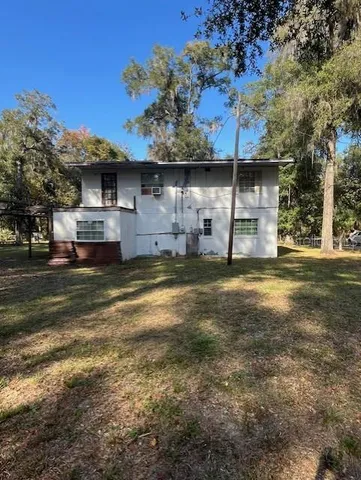 a view of a large house with a large tree and a big yard