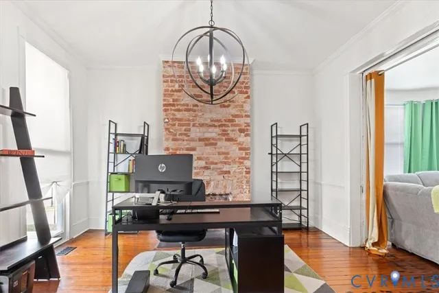 a view of a workspace with furniture and a window