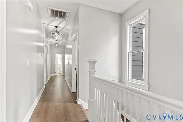 a view of a hallway with wooden floor and staircase