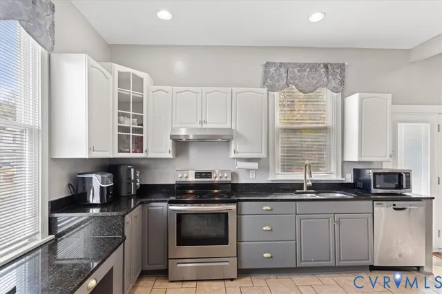 a kitchen with stainless steel appliances granite countertop a sink a stove and a granite counter tops