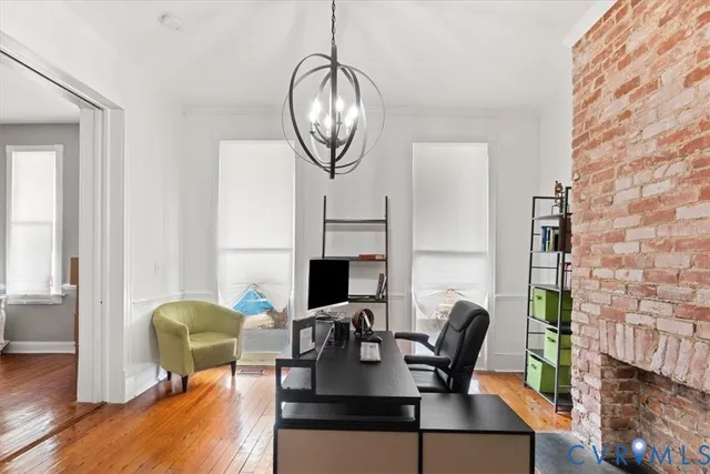 a dining room with furniture a fireplace and wooden floor
