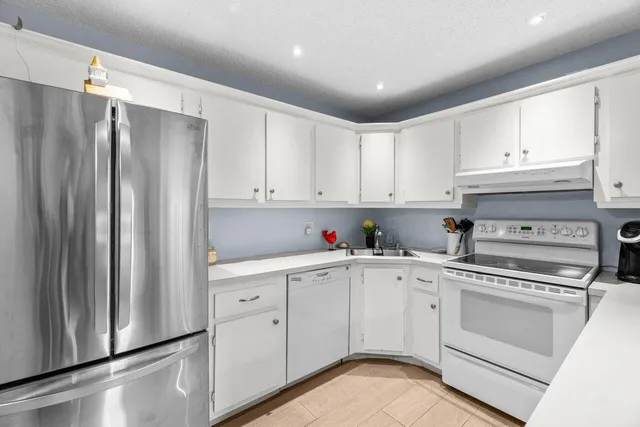a kitchen with white cabinets and white appliances