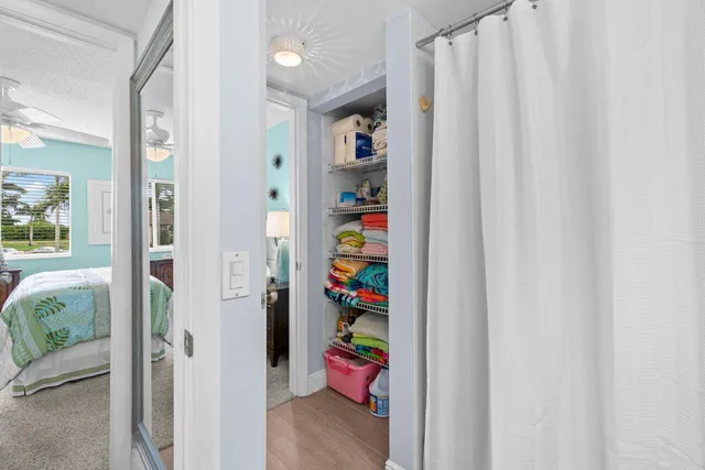 a view of a hallway with wooden floor and closet