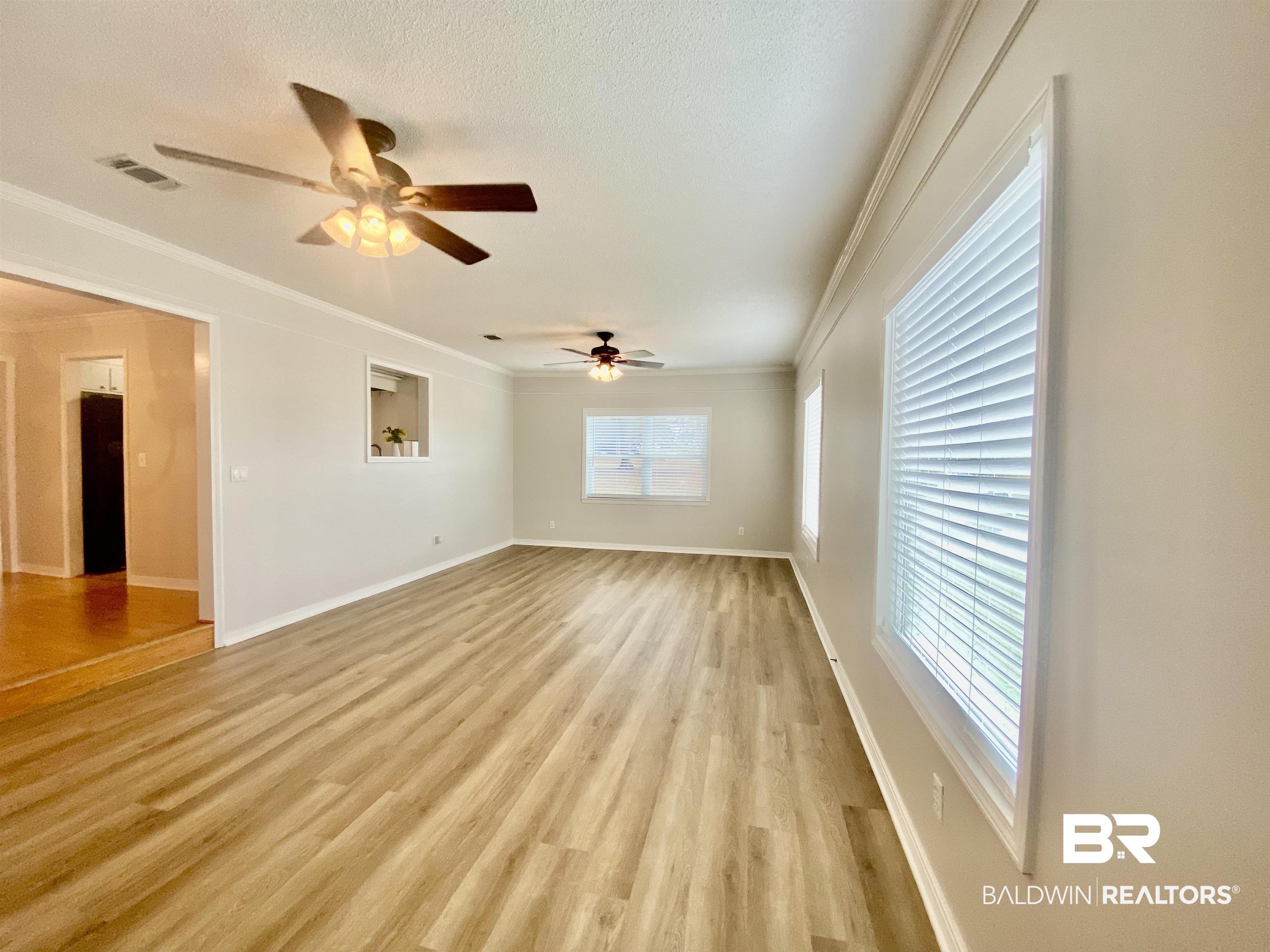 265 Azalea Drive Monroeville, AL 36460 - Photo 14 of 39 Spare room with ornamental molding, light hardwood / wood-style floors, a textured ceiling, and ceiling fan