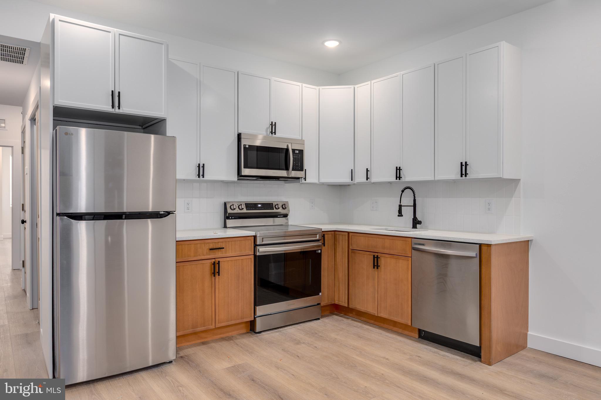 2203 North 7th Street, Unit 3 Philadelphia, PA 19133 - Photo 2 of 13 a kitchen with stainless steel appliances a refrigerator sink and microwave
