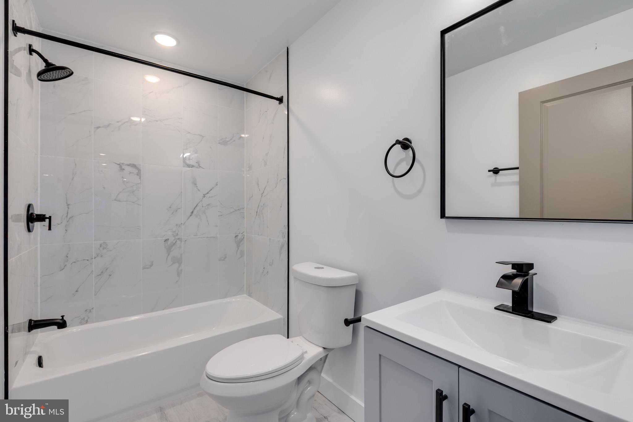 2203 North 7th Street, Unit 3 Philadelphia, PA 19133 - Photo 7 of 13 a bathroom with a granite countertop sink a toilet and shower
