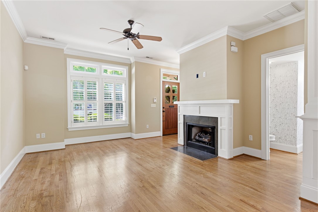 204 Butler Avenue Greenville, SC 29601 - Photo 5 of 26 An inviting living area showcasing hardwood flooring, a gas fireplace, and a welcoming front entrance.