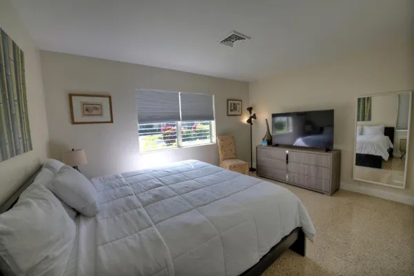 a bedroom with a bed and a flat screen tv