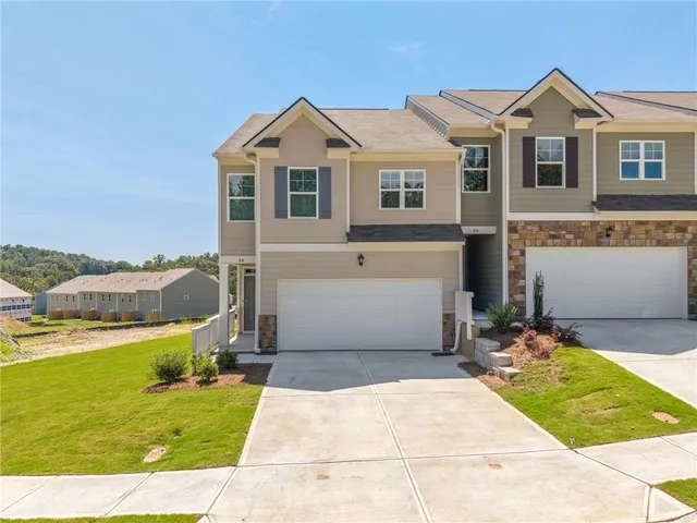 a view of a white house with a yard and sitting area