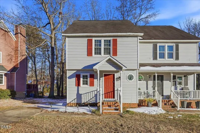 a view of a white house with large windows next to a road