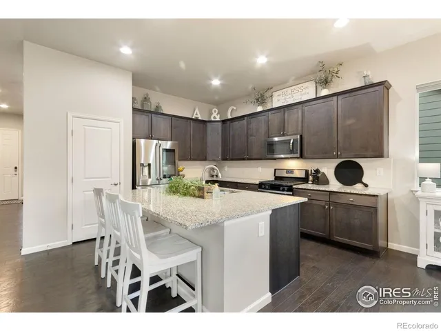 a kitchen with cabinets a sink stainless steel appliances and dining table