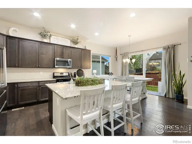 a kitchen with stainless steel appliances kitchen island granite countertop a stove a sink a microwave and a refrigerator