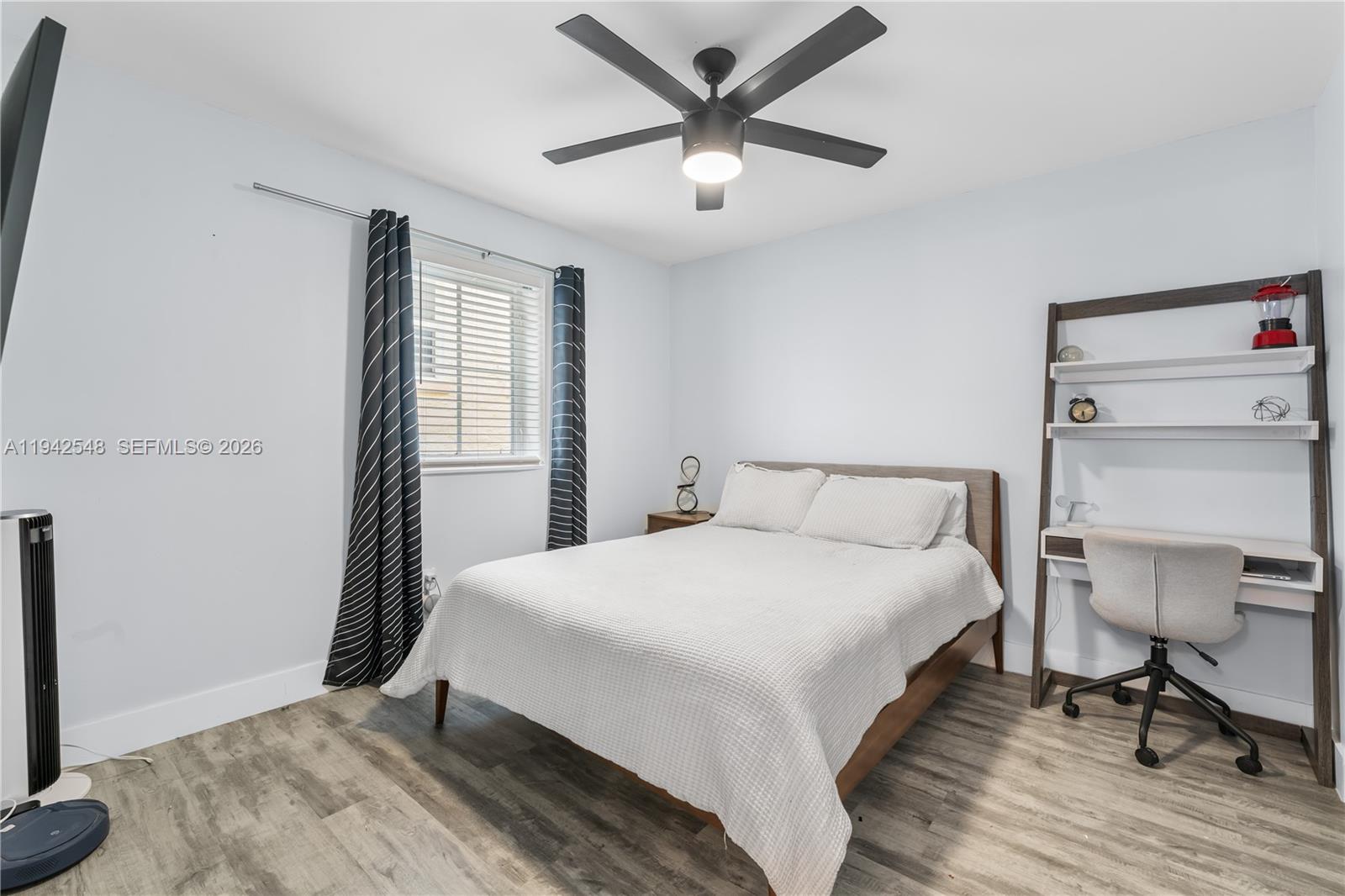 1308 Drexel Avenue, Unit 209 Miami Beach, FL 33139 - Photo 12 of 13 a bedroom with a bed and a chandelier