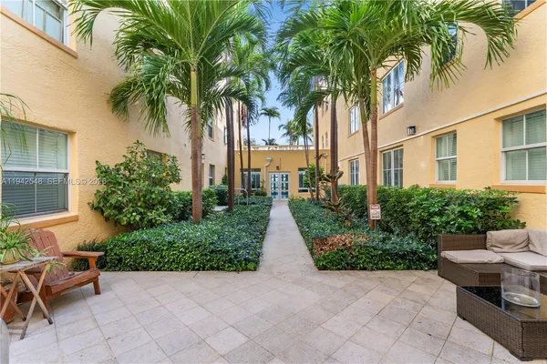 a view of a patio with table and chairs potted plants and palm tree