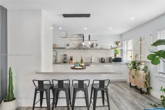 a kitchen with granite countertop white cabinets and chairs