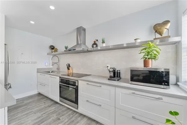 a kitchen with stainless steel appliances a sink a stove and cabinets