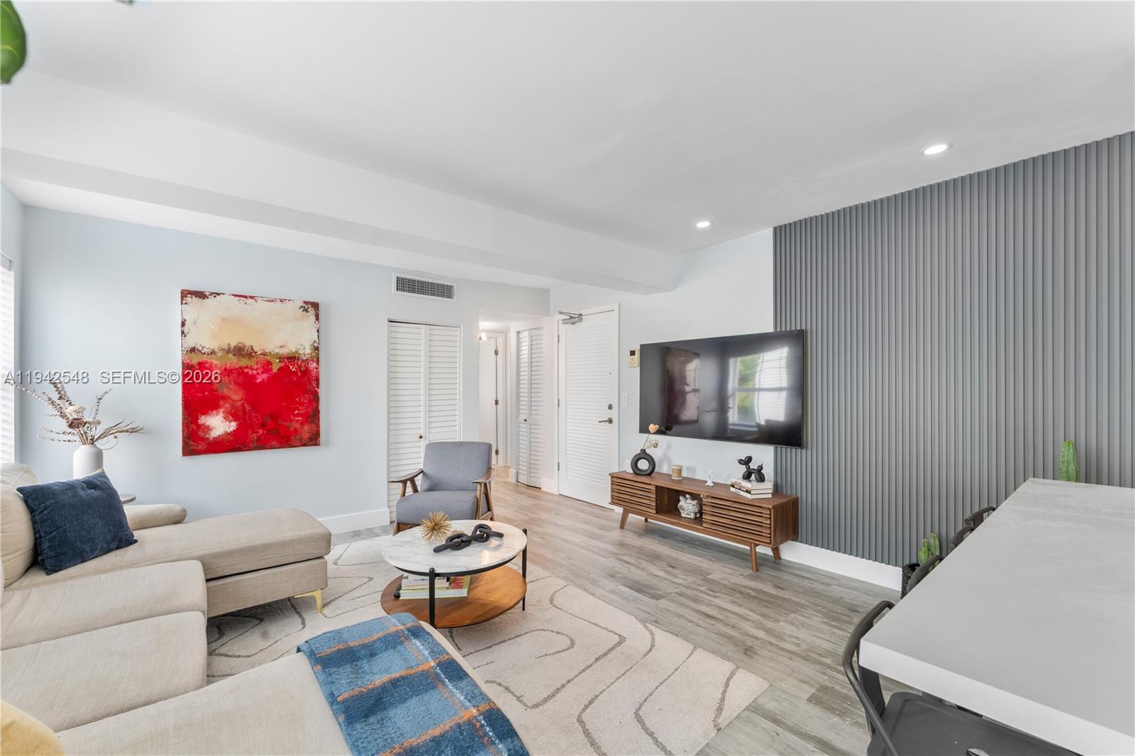 1308 Drexel Avenue, Unit 209 Miami Beach, FL 33139 - Photo 8 of 13 a living room with furniture and a flat screen tv