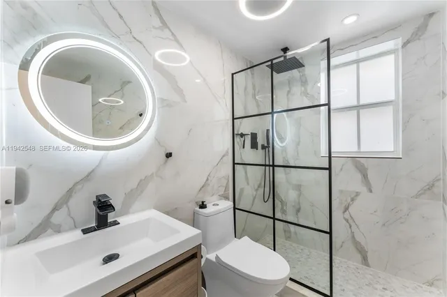 a bathroom with a sink mirror vanity and toilet