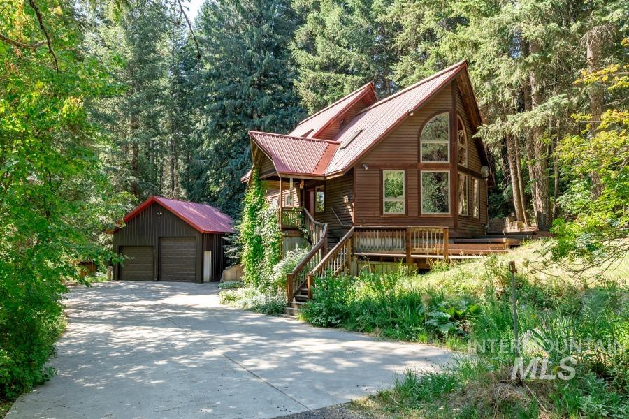 1026 Showalter Road Moscow, ID 83843 - Photo 1 of 1 Chalet / cabin featuring an outbuilding, a detached garage, a forest view, and a metal roof