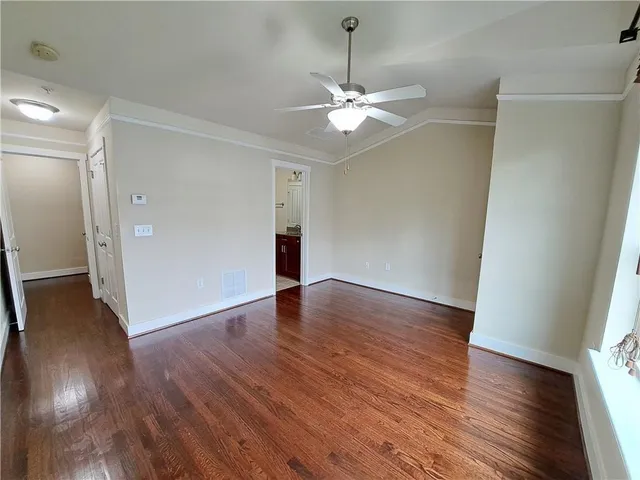 an empty room with wooden floor and window