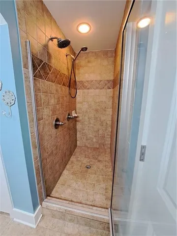 a bathroom with a glass door shower a sink and vanity