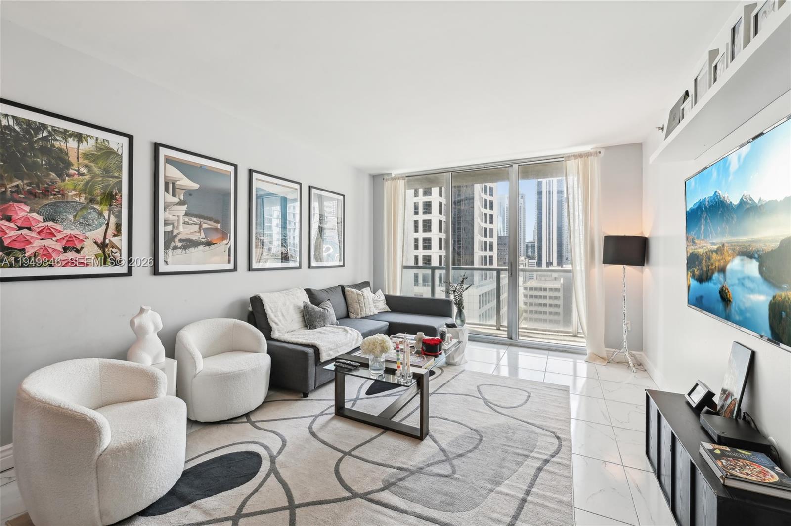 55 Southeast 6th Street, Unit 1608 Miami, FL 33131 - Photo 1 of 24 Modern open-concept living room with floor-to-ceiling windows offering panoramic views of Brickell skyline and Miami River. Luxury high-rise condo in the heart of Brickell.
