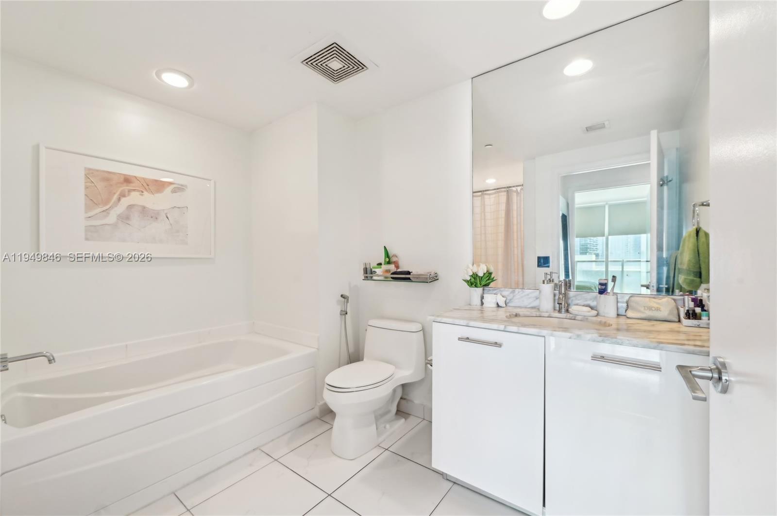 55 Southeast 6th Street, Unit 1608 Miami, FL 33131 - Photo 11 of 24 Luxury bathroom with elegant finishes, frameless glass shower, and modern vanity design.