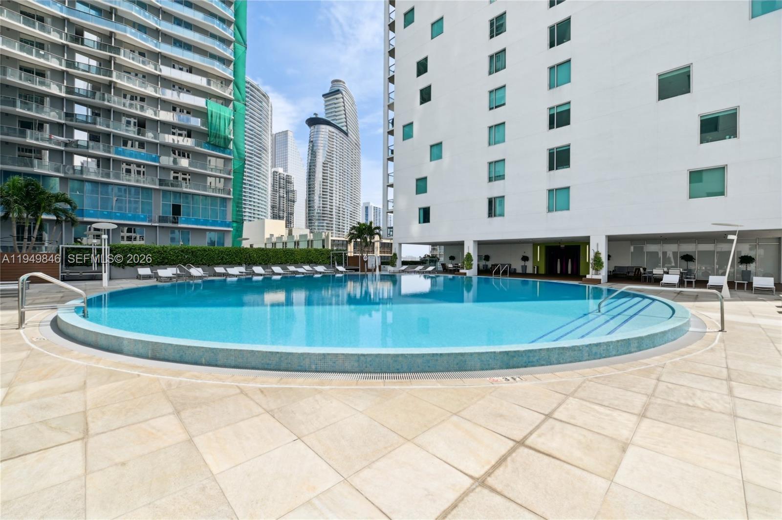 55 Southeast 6th Street, Unit 1608 Miami, FL 33131 - Photo 16 of 24 Resort-style rooftop pool with sundeck overlooking Brickell skyline, ideal for relaxation.