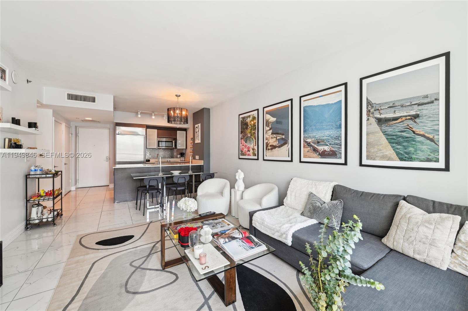 55 Southeast 6th Street, Unit 1608 Miami, FL 33131 - Photo 4 of 24 Bright living area with sleek finishes, abundant natural light, and direct access to balcony with city views.