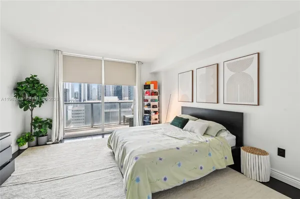 a bedroom with a large bed and a potted plant