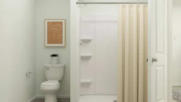 a bathroom with a toilet and a shower
