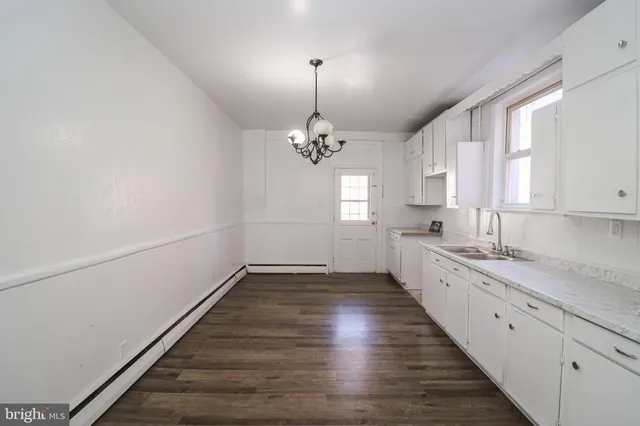 a large kitchen with a white cabinets and window