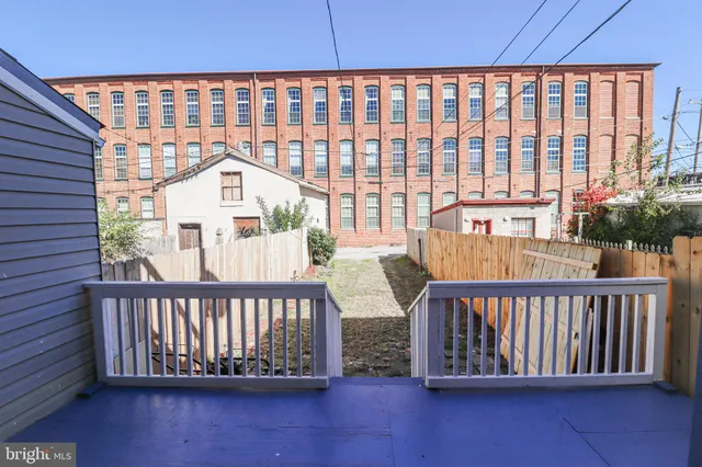 a view of a backyard with potted plants and wooden fence