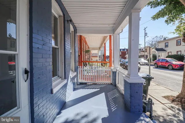 a view of a porch with wooden floor and iron fence