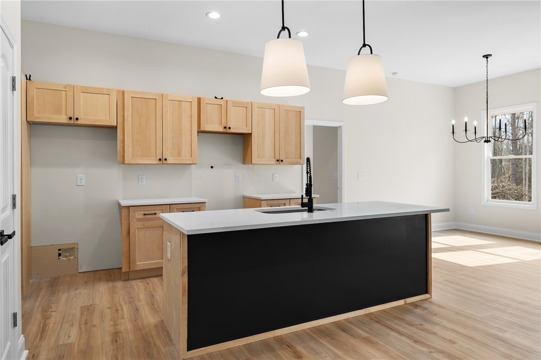 333 Lone Oak Road Anderson, SC 29621 - Photo 10 of 36 This bright kitchen features an island, ample cabinetry, and rich hardwood flooring, creating a welcoming atmosphere.