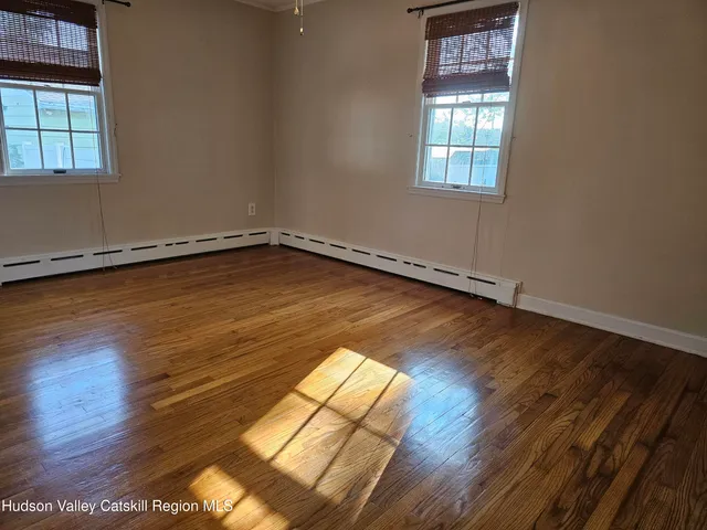 a view of a room with wooden floor and window