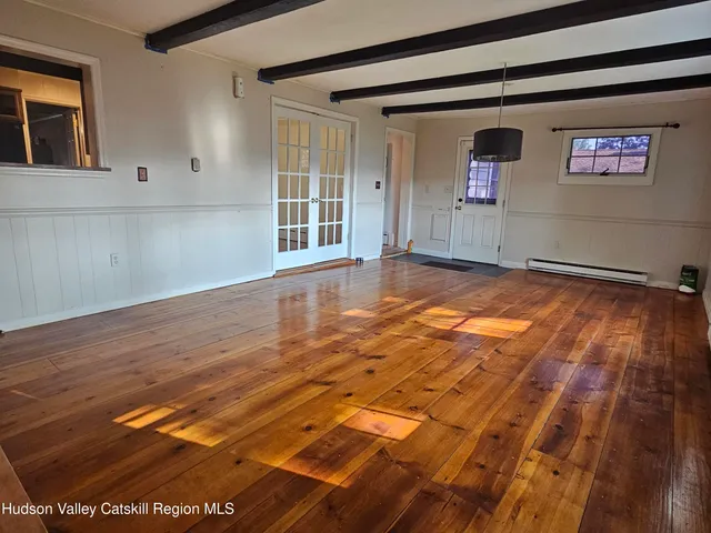 a view of a livingroom with wooden floor and windows