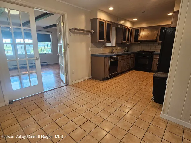 a kitchen with stainless steel appliances kitchen island granite countertop a refrigerator and a sink