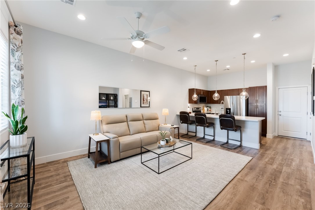 6432 Spring Jog Street Las Vegas, NV 89166 - Photo 6 of 61 An open-concept living space with abundant natural light transitions seamlessly into a well-appointed kitchen.