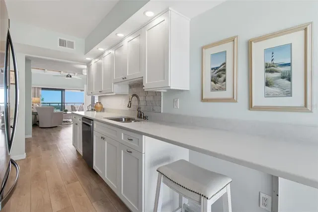 a kitchen with a sink cabinets and wooden floor