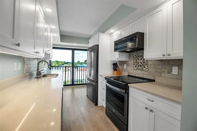 a kitchen with stainless steel appliances granite countertop a stove a sink and a microwave