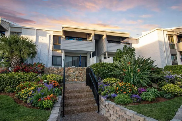 a front view of a house with a yard and flowers