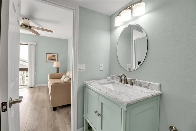 a en suite bathroom with a granite countertop sink and a mirror