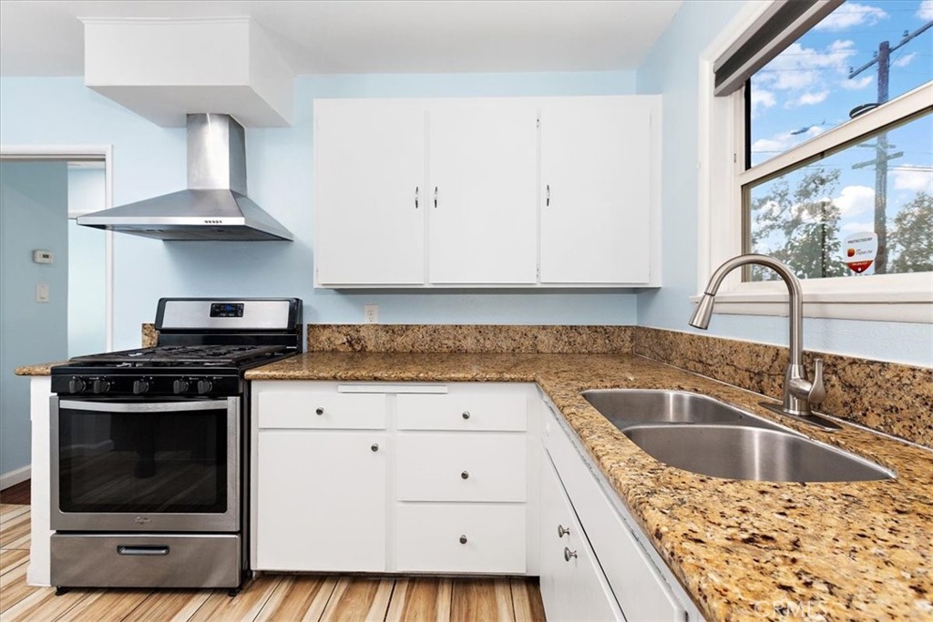 4485 Dwight Avenue Riverside, CA 92507 - Photo 5 of 15 a kitchen with granite countertop a stove sink and cabinets