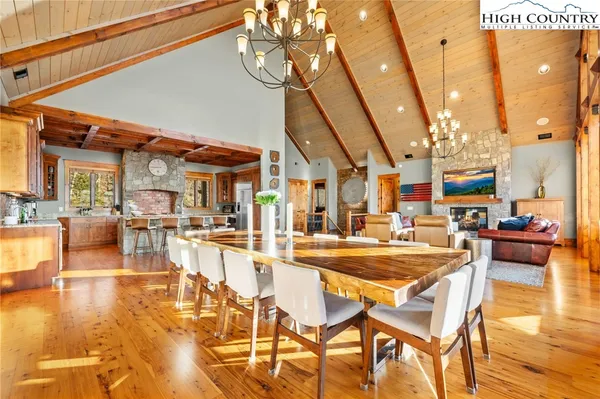 a dining room with lots of wooden furniture and chandelier
