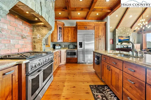 a large kitchen with stainless steel appliances granite countertop a stove and a sink
