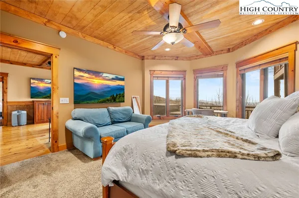 a bedroom with a bed a couch and a flat screen tv