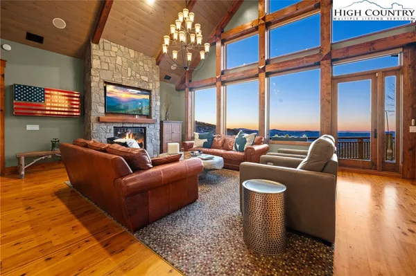 a living room with furniture a chandelier and a fireplace