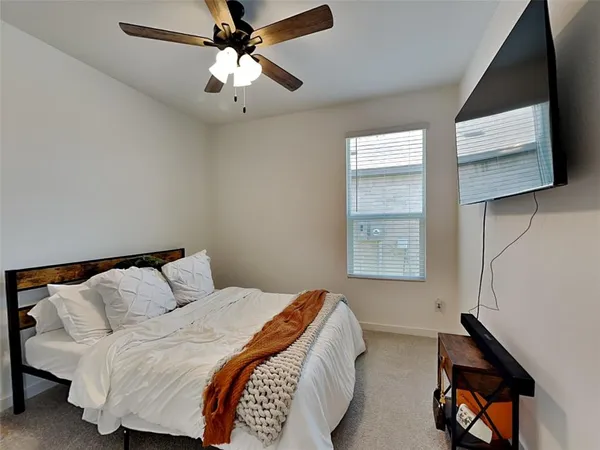 a bedroom with a bed a window and painting on the wall