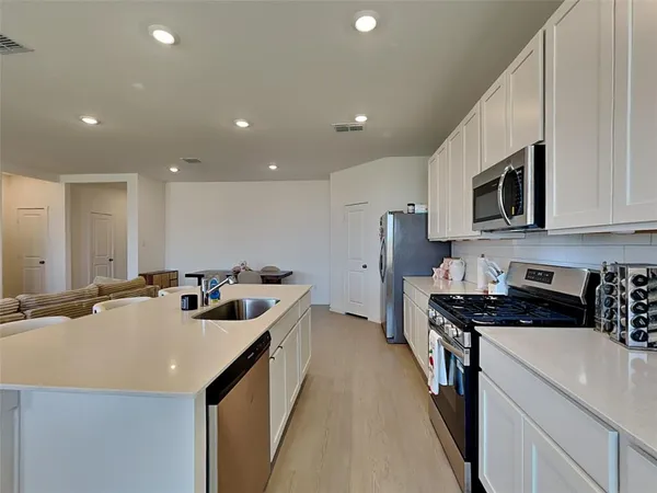 a kitchen that has a lot of cabinets and wooden floor